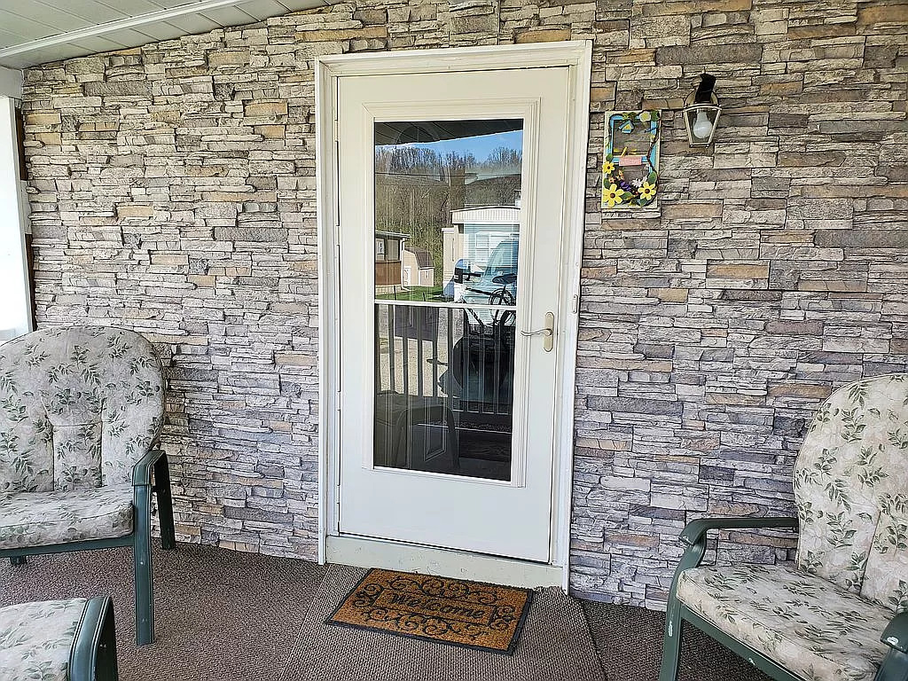 mobile home with stone on each side of the front door