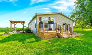 A Stylish Mobile Home Exterior with Front Deck and Back Patio