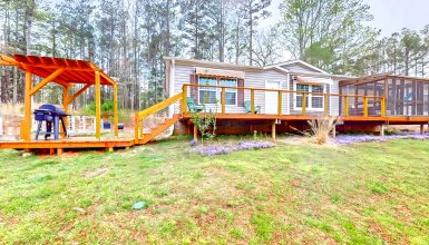 Mobile Home Exterior with A Screened-In Porch, A Deck, and A Pergola