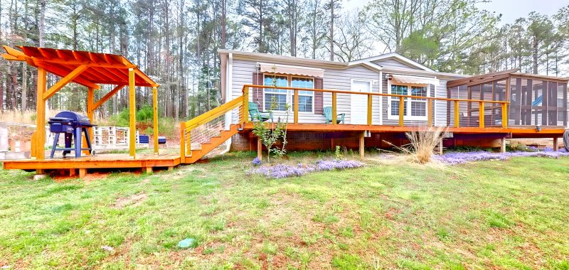 Mobile Home Exterior with A Screened-In Porch, A Deck, and A Pergola