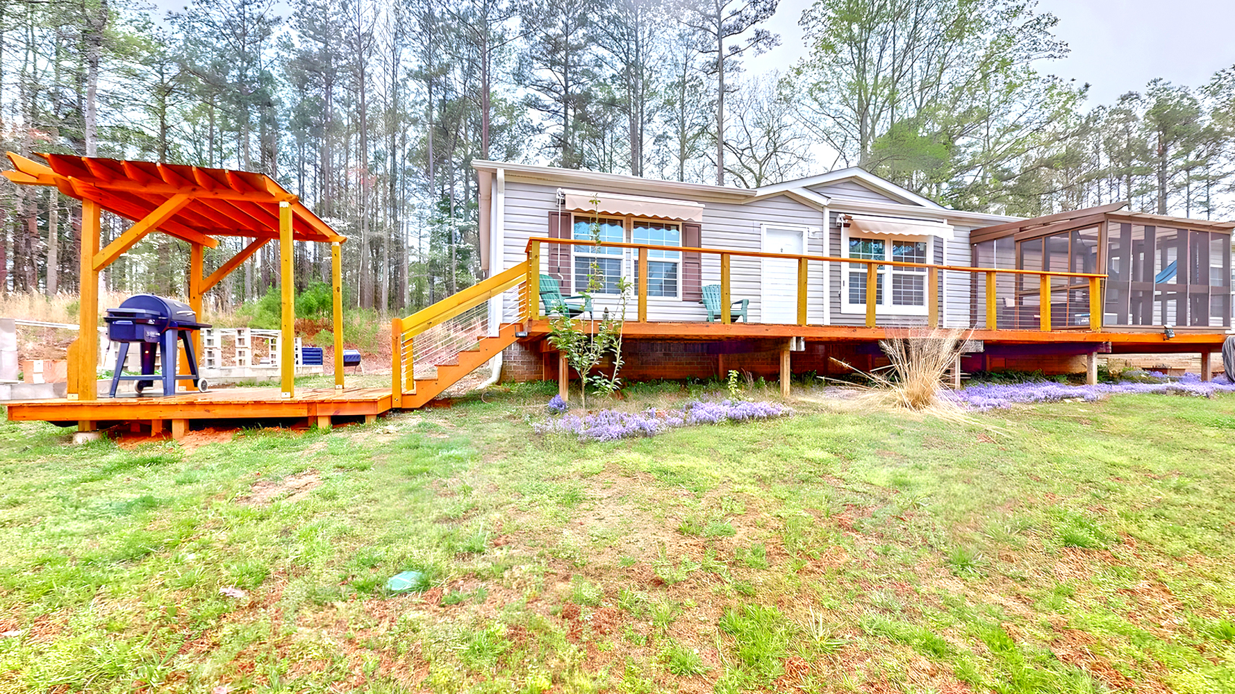 Mobile Home Exterior with A Screened-In Porch, A Deck, and A Pergola