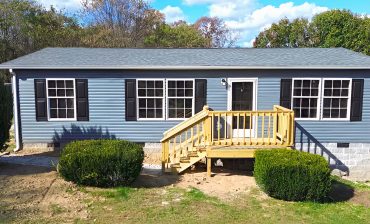 Gray Mobile Home with Black Shutters