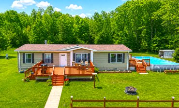Mobile Home Exterior With a Spacious Deck and Pool